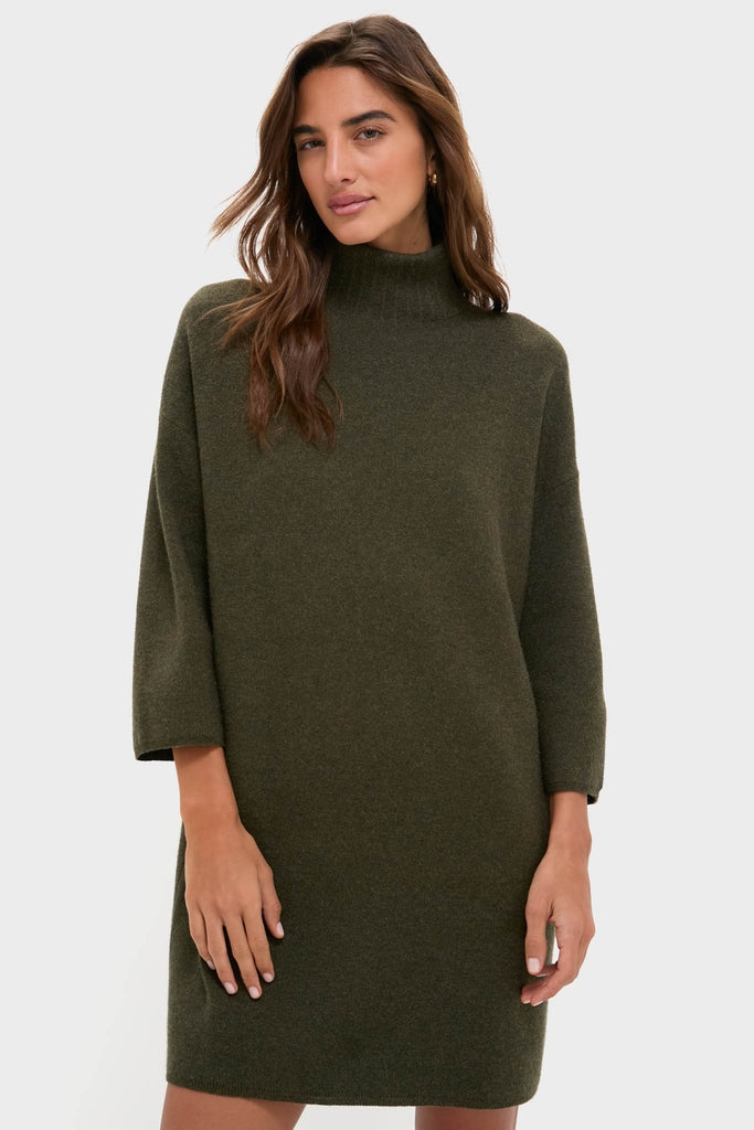 Woman wearing the Moss Green Vivianne Dress; an effortless, classic sweater dress with three-quarter sleeves and a mock turtleneck, exuding fun sophistication and high-end style.