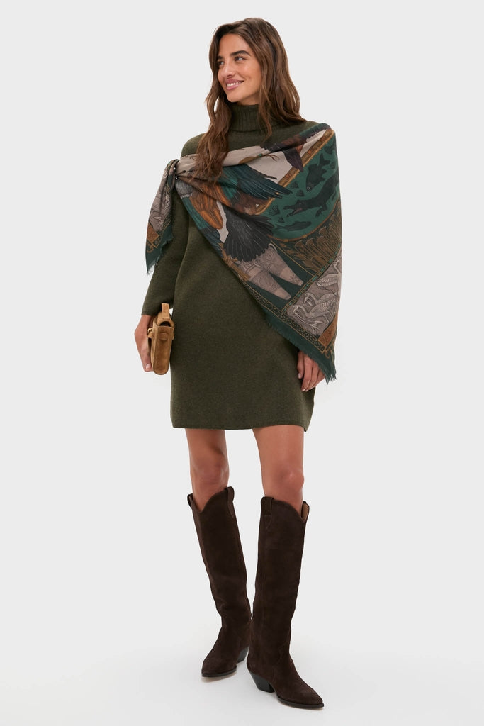 Woman models the Moss Green Vivianne Dress—a classic, effortless sweater dress—paired with a fringed nature-print scarf, dark suede boots, and a tan clutch, embodying high-end fall fashion.