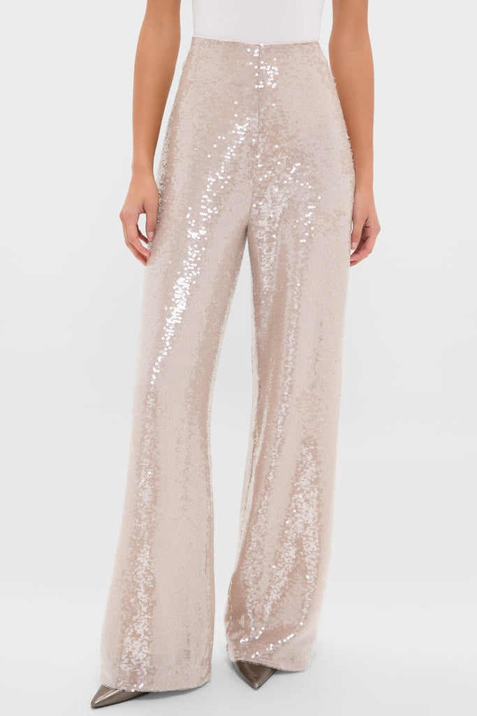 Woman wearing Champagne Sequin Tatum Pants, featuring a high-rise, wide-leg design with light-champagne sequins, paired with a white top and heels, exuding classic, effortless elegance.