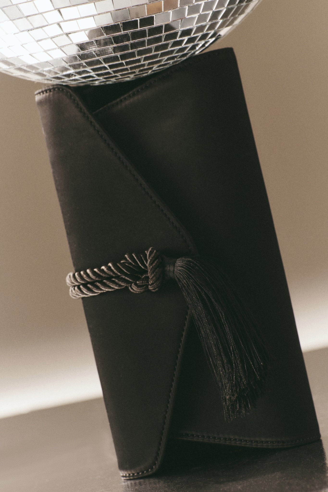 Black Satin Gabrielle Clutch with a braided tassel, exuding classic elegance and effortless sophistication, perfect for high-end, fun evenings or special occasions.