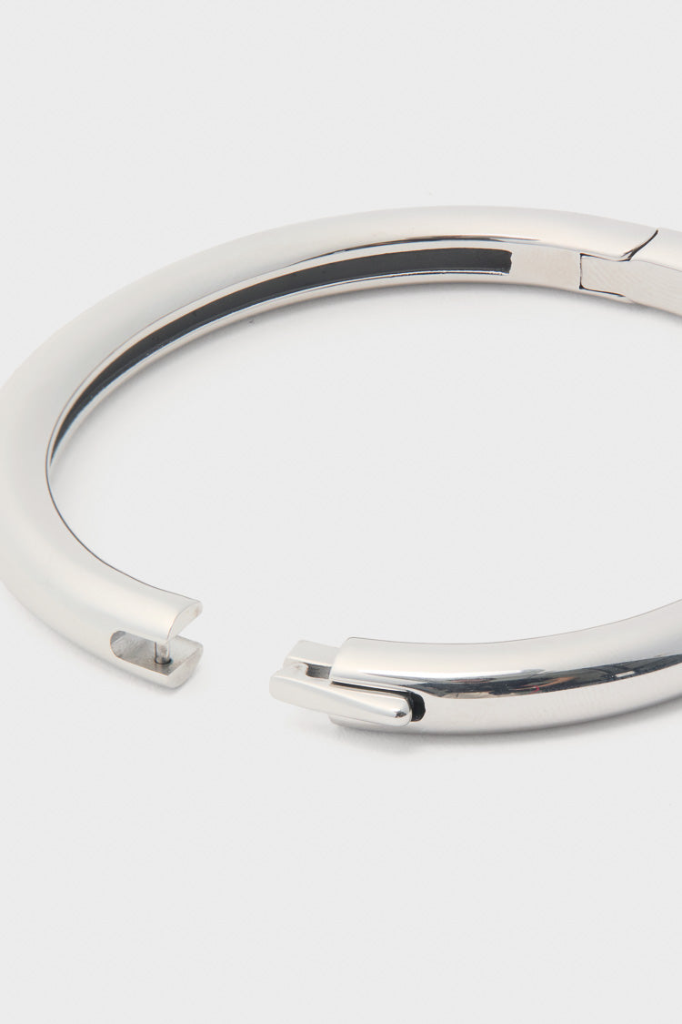Silver Gia Bangle with high-polish finish and hinge push closure, showcasing its classic pin-and-slot mechanism. An effortless, high-end accessory for a fun, sophisticated look.