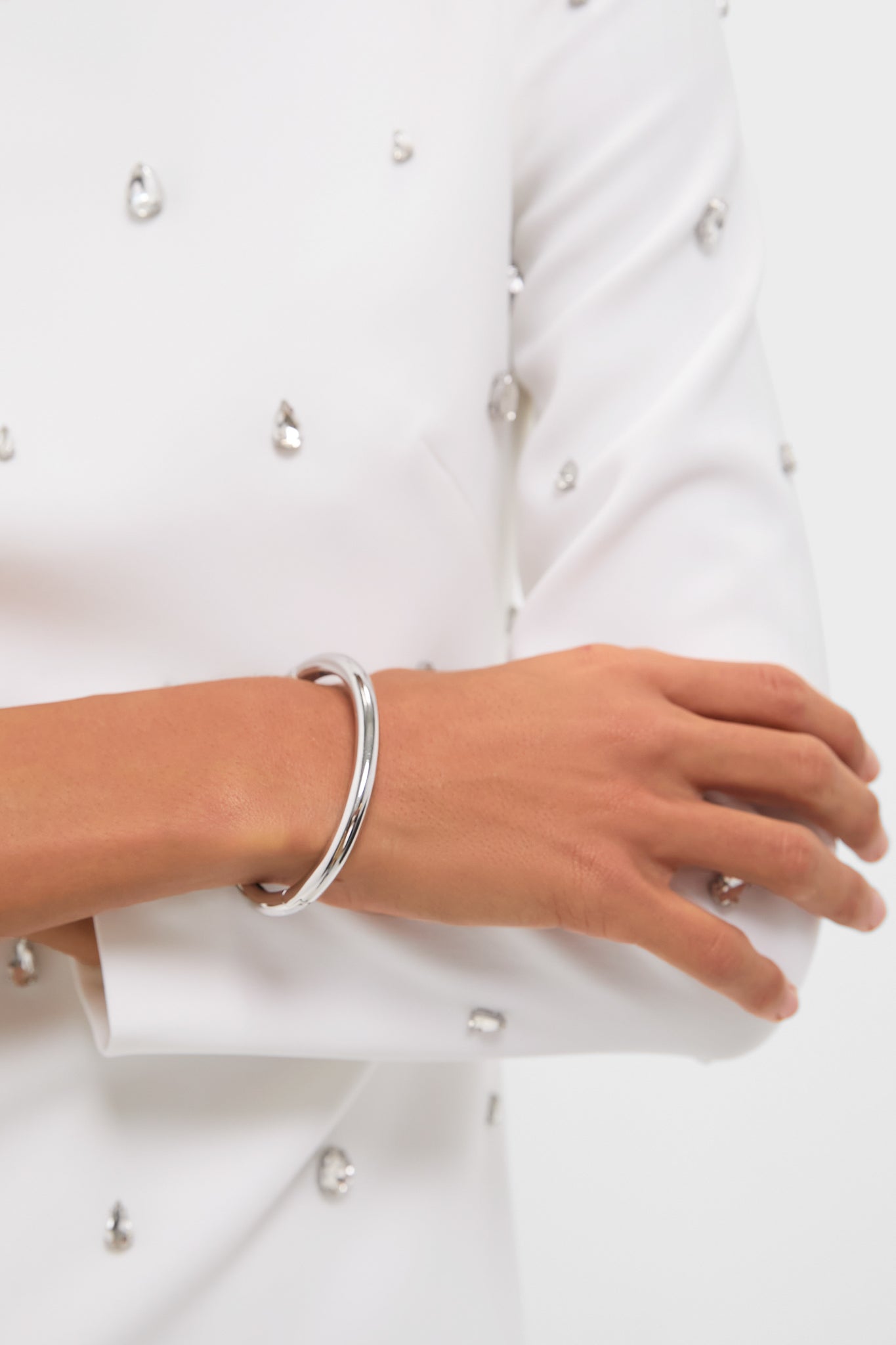 Close-up of forearms showcasing the Silver Gia Bangle, a classic, high-end bracelet with a polished finish, embodying effortless style and fun sophistication.
