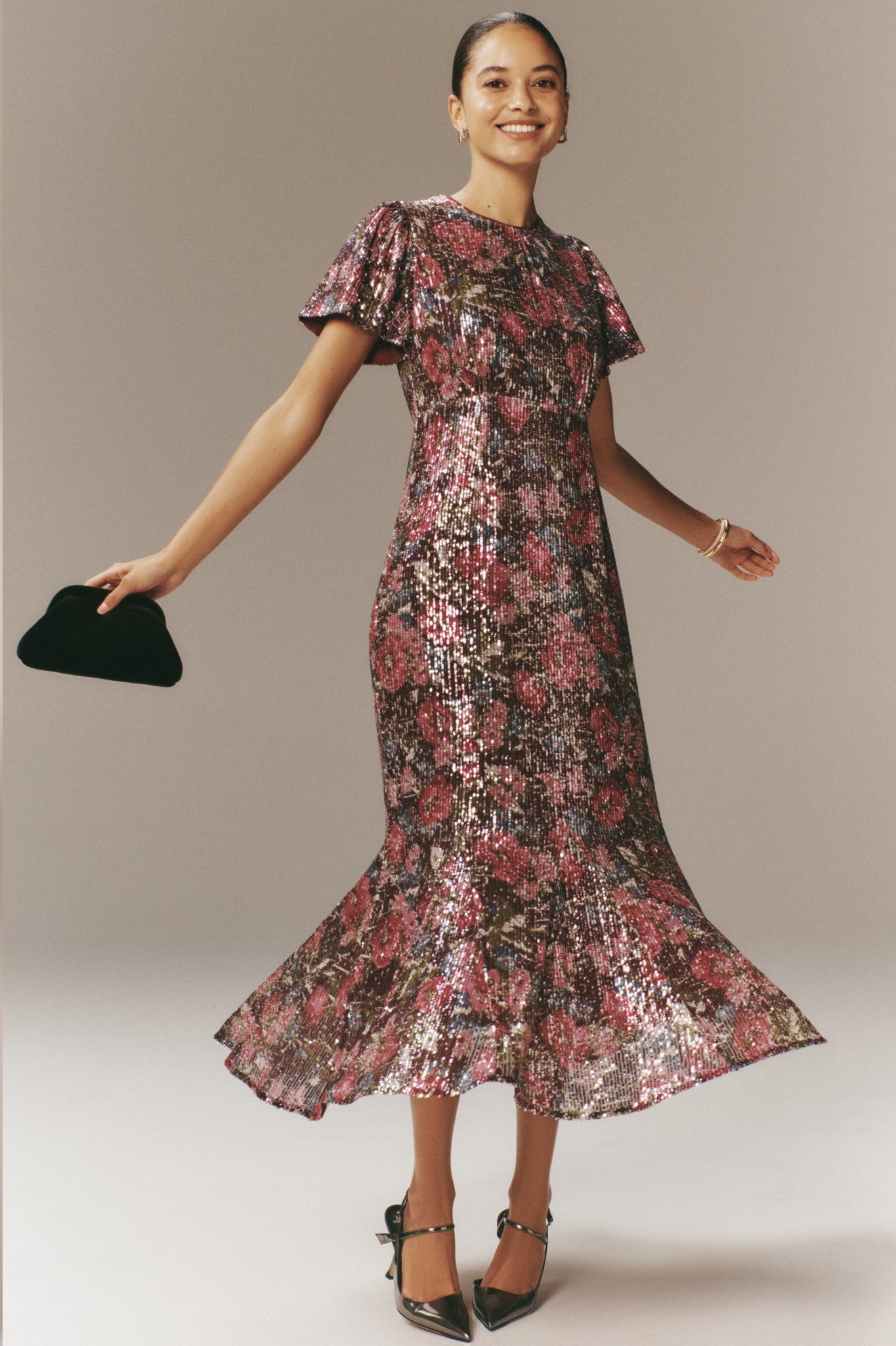 Floral Sequin Elodie Dress: A classic, effortless party dress with flutter sleeves and a flared hem, paired with heels and a clutch for a fun, high-end look.