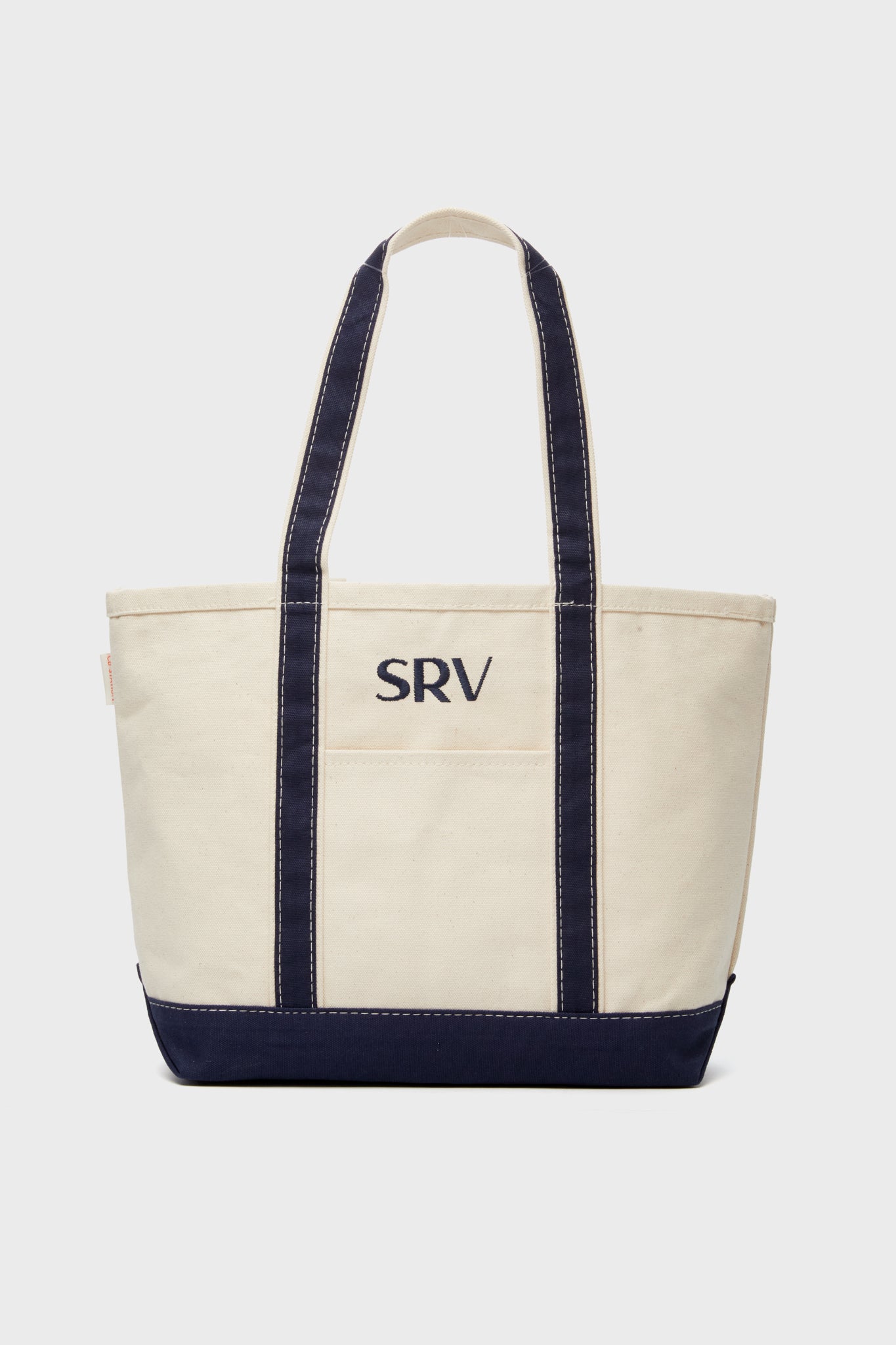 A CB Station beige boat tote with navy straps and base, personalized with SRV monogram embroidered in navy on the front.
