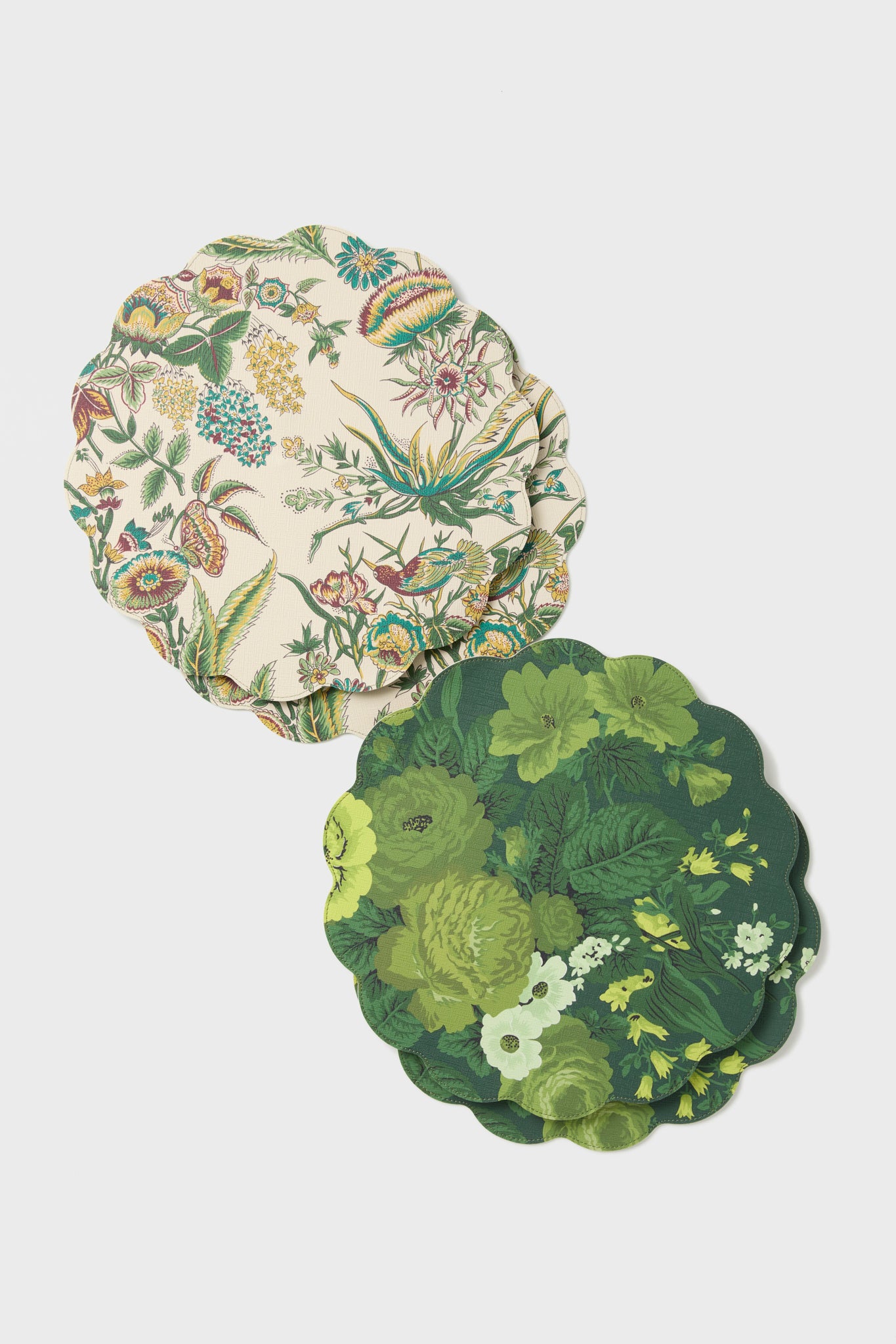 Two scalloped-edged coasters by Metrobazaarstore Home, made of polyurethane leather with colorful floral designs, are stacked on a white surface. These reversible coasters add both style and practicality to your table setting.