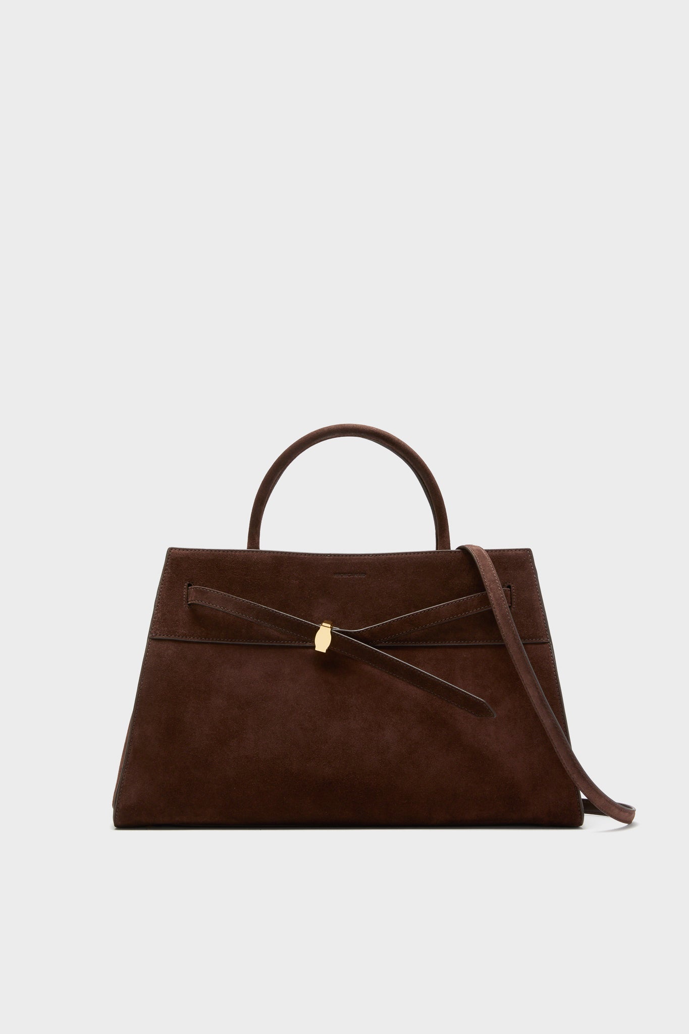 A Veronica Beard brown Italian suede bag with a top handle, gold clasp, and removable shoulder strap is shown against a plain, light background.
